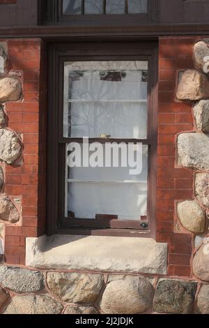 Vintage Holzfenster auf einem charmanten rustikalen Steinhaus. Stockfoto