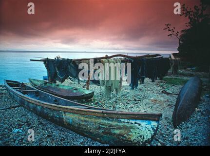 Salomonen. Guadalcanal. Honiara. Fischerboote und Netze am Kiesstrand. Stockfoto