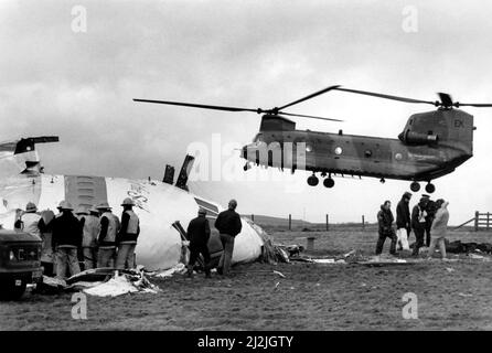 Die Flugkatastrophe von Lockerbie, die sich am 21.. Dezember 1988 ereignete. Beteiligt war die Pam Boeing 747-121, Clipper Maid of the Seas. Ein Hubschrauber der RAF Boeing Chinook landet an der Absturzstelle, während die grausame Suche fortgesetzt wird, während Rettungskräfte das Wrack untersuchen. 23/12/1988 Stockfoto