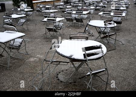 München, Deutschland. 02. April 2022. Die Tische sind im Hofgarten mit Schnee bedeckt. In München hat es geschneit. Quelle: Felix Hörhager/dpa/Alamy Live News Stockfoto