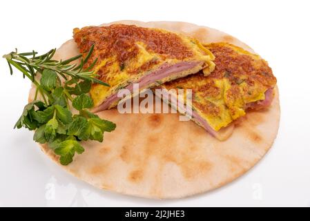 Omelette mit Kräutern gefüllt mit Schinken und Käse auf Fladenbrot isoliert auf weißem, schneidendem Pfad Stockfoto