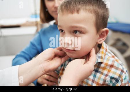 Arzt Hände klopfen Kind Lymphknoten mit den Fingern Stockfoto