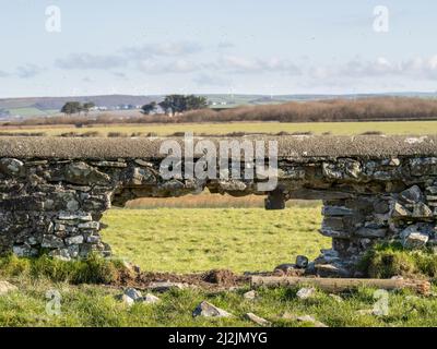 Loch in einer alten Steinmauer, ländlicher Hintergrund. Stockfoto