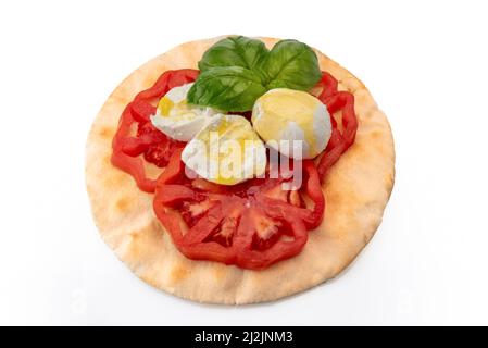 Caprese Salat mit Tomaten Mozzarella Olivenöl und Basilikumblättern auf italienischem Fladenbrot, Piadina, Isolato su bianco, Schneideweg Stockfoto