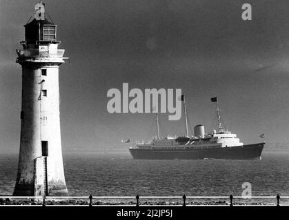 Königin Elizabeth II besucht Liverpool, Merseyside. Die HMS Brittania macht ihren majestätischen Weg vorbei am Leuchtturm von Perch Rock auf der Mersey. Datum des Bildes 8. August 1988 Stockfoto