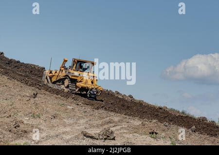 Trossingen, 25. Juni 2020. Auf dem Weg in den Himmel. Caterpillar Bulldozer, die Arbeit der Erde auf einem steilen Hügel der Erde auf der Erde Dump . Stockfoto