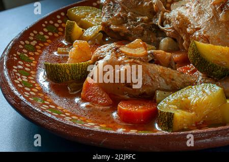 Huhn mit Gemüse und Tomatensoße in einer mexikanischen Tonplatte. Mexicam Food-Konzept. Seitenansicht Makrofotografie Stockfoto