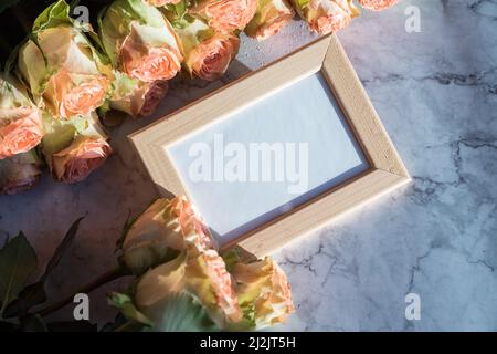 Goldrahmen mit Dekorationen. Mock up für Ihr Foto oder Text Platzieren Sie Ihre Arbeit, Druckkunst, Rosen in Vase Stockfoto