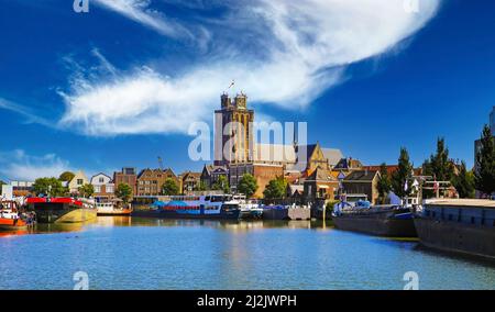 Dordrecht, Niederlande - Juli 9. 2021: Blick über den holländischen Binnenhafen auf die Skyline der Altstadt mit Kirchturm vor blauem Sommerhimmel Stockfoto