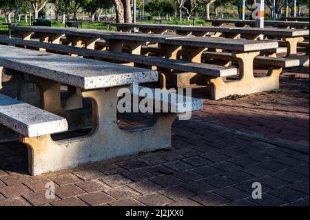 Leere Tische mit Picknickbänken im Park sonnige Tagesperspektive. Nahaufnahme. Stockfoto