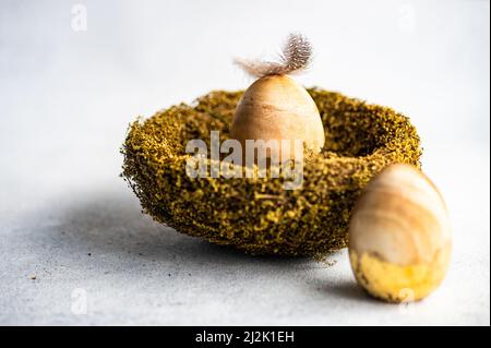 Feder auf einem goldenen Osterei in einem Vogelnest Stockfoto