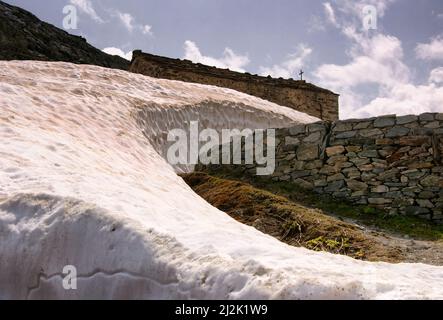 Schneeverwehung neben einer Kirche, Great St Bernard Pass, Schweiz Stockfoto