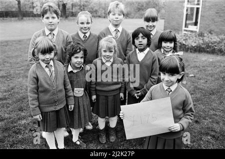 Alle 420 Schüler der St. Patrick's RC Primary School, Birkby, halfen dabei, £175 für den Examiner Bodyscanner Appeal zu sammeln. Lisa Bedford (vorne) und einige der anderen an der Spendenbeschaffung beteiligten Personen sind mit dem wichtigen Umschlag mit dem Scheck abgebildet. Das Geld kam aus einer von den Junioren inszenierten Disco und aus Programm, Pop und knackigen Verkäufen an einem Sporttag für die Kleinkinder. 10.. November 1987. Stockfoto