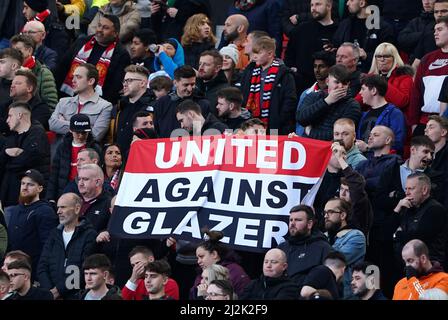Manchester United Fans in den Tribünen halten ein Banner mit der Aufschrift „United Against Glazer“ während des Spiels der Premier League in Old Trafford, Manchester, hoch. Bilddatum: Samstag, 2. April 2022. Stockfoto