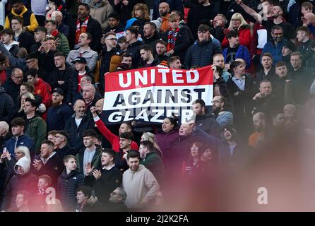 Manchester United Fans in den Tribünen halten ein Banner mit der Aufschrift „United Against Glazer“ während des Spiels der Premier League in Old Trafford, Manchester, hoch. Bilddatum: Samstag, 2. April 2022. Stockfoto