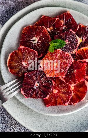 Nahaufnahme einer Platte aus geschälten und geschnittenen sizilianischen Blutorangen von oben Stockfoto