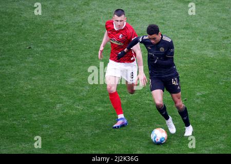 Freiburg Im Breisgau, Deutschland. 02. April 2022. Fußball: Bundesliga, SC Freiburg - Bayern München, Matchday 28, Europa-Park Stadion: Jonathan Schmid aus Freiburg im Duell mit Jamal Musiala aus München Credit: Philipp von Ditfurth/dpa - WICHTIGER HINWEIS: Gemäß den Anforderungen der DFL Deutsche Fußball Liga und des DFB Deutscher Fußball-Bund ist es untersagt, im Stadion und/oder vom Spiel aufgenommene Fotos in Form von Sequenzbildern und/oder videoähnlichen Fotoserien zu verwenden oder zu verwenden./dpa/Alamy Live News Stockfoto