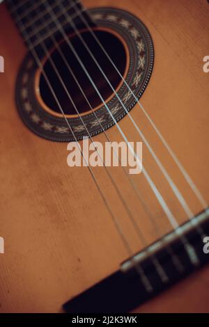 Nahaufnahme einer klassischen Holzgitarre mit Plastiksaiten. Stockfoto