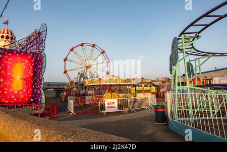 Das Messegelände bietet Fahrgeschäfte und Attraktionen im Jahrmarkt an der Hunstanton Promenade. Aufgenommen am späten Nachmittag, gerade als die Sonne untergeht Stockfoto