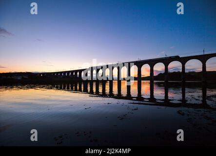 Eine länderübergreifende Züge Intercity 125 Kreuzung die Royal Border Bridge, Berwick upon Tweed mit der Silhouette im Wasser bei Sonnenuntergang widerspiegelt. Stockfoto