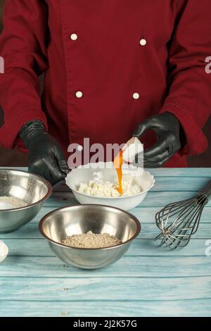 Trennung der Eigelbe von den Weißen in rohen Eiern für die Herstellung eines Kuchens. Stockfoto