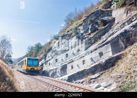 Spitz: Felsanker an der Felswand neben der Eisenbahnlinie, Felsformation Teufelsmauer, Zug der Wachaubahn von NÖVOG, Bahnlinie Donauuferbahn in Wachau, Stockfoto