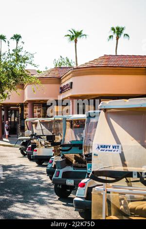 Reihe von Golfwagen auf einem Strip Mall Parkplatz in Sun City, Arizona, USA geparkt. Stockfoto