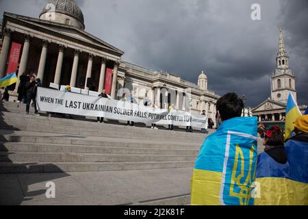 London, Großbritannien. 2. April 2022. Auf dem Trafalgar Square wird ein Transparent hochgehalten, wo sich die Menschen versammelt haben, um Solidarität mit der Ukraine zu zeigen und ein Ende des Krieges zu fordern. Quelle: Kiki Streitberger/Alamy Live News Stockfoto