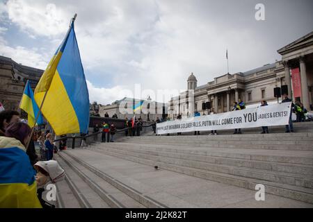 London, Großbritannien. 2. April 2022. Auf dem Trafalgar Square wird ein Transparent hochgehalten, wo sich die Menschen versammelt haben, um Solidarität mit der Ukraine zu zeigen und ein Ende des Krieges zu fordern. Quelle: Kiki Streitberger/Alamy Live News Stockfoto