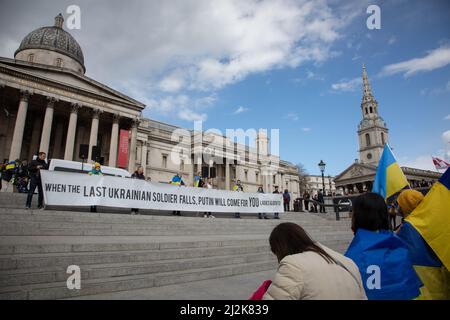 London, Großbritannien. 2. April 2022. Auf dem Trafalgar Square wird ein Transparent hochgehalten, wo sich die Menschen versammelt haben, um Solidarität mit der Ukraine zu zeigen und ein Ende des Krieges zu fordern. Quelle: Kiki Streitberger/Alamy Live News Stockfoto