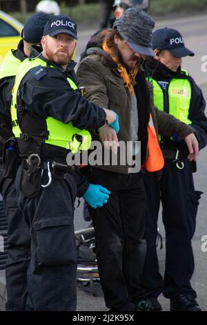 Grays, Thurrock, Großbritannien 2. April 2022 Stoppt einfach Öl Demonstranten blockieren Straßen am Thurrock Öldepot. Vier Demonstranten bestiegen einen Öltanker, der sich mit Schleusen auf dem Dach sicherte, während eine andere Gruppe eine Holzkonstruktion schuf, die einen Tunnel deckte, der unter der Straße ausgegraben wurde. Die vier Demonstranten wurden von den Rettungsdiensten mit einer Bahre entfernt und anschließend verhaftet. Kredit: Denise Laura Baker/Alamy Live Nachrichten Stockfoto