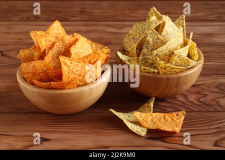 Tortilla Chips Nachos’ Mexican und Tortilla Chips mit Chia Samen in Bambusschalen auf Holztisch. Nahaufnahme Stockfoto