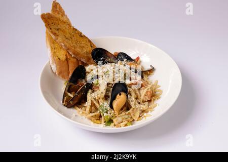 SEAFOOD SPAGHETTI Pasta - LA SCOLGIO mit Knoblauchbrot in einem Gericht Draufsicht auf grauen Hintergrund singapur Essen Stockfoto
