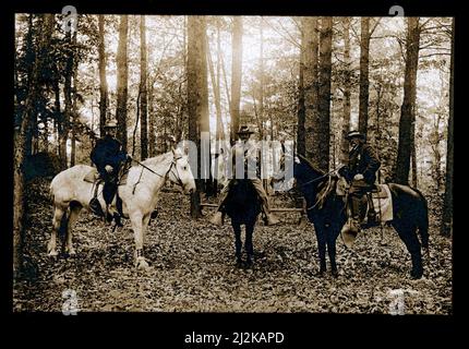 Drei Männer auf dem Pferderücken, c. 1890s, mit Abzeichen, New England USA. Stockfoto