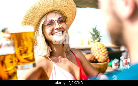 Freunde trinken und toasten Bier in der Brauerei Bar chiringuito - Life Style Konzept mit jungen trendigen Paar Spaß zusammen auf Happy Hour am Strand Stockfoto