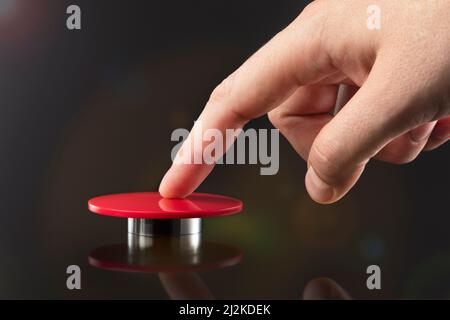 Die Hand drückt den großen roten Knopf. Das Konzept der Bedrohung durch einen Atomkrieg. Eine Bedrohung für die Welt mit einem nuklearen Koffer und einer Bombe. Die Hand Stockfoto