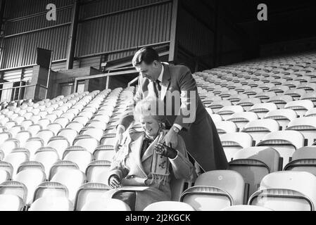 Margaret Thatcher PM, Visits Valley Parade, Heimstadion des Bradford City Football Club, Freitag, 20.. Februar 1987. Der Premierminister inspizierte die Sanierung des Valley Parade Ground, die nach einem verheerenden Brand am Samstag, dem 11.. Mai 1985, erforderlich war, bei dem 56 Menschen ums Leben kamen und mindestens 265 weitere verletzt wurden. Unser Bild zeigt ... Chairman Stafford Heginbotham drapiert Margaret Thatcher einen Clubschal, während der Premierminister in der leeren neuen Tribüne sitzt. Stockfoto