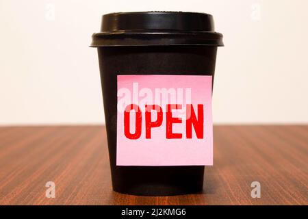 OFFEN FÜR GESCHÄFTE - Wörter, die weiße Buchstaben auf ein Blatt schreiben. Schwarze Karte mit Text auf gelbem Hintergrund mit rundem Metallständer und Metallwriti Stockfoto