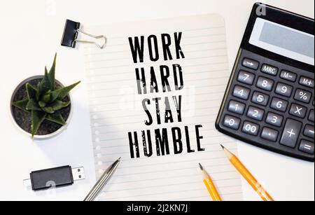 Wortzitate der ARBEIT HART BLEIBEN BESCHEIDEN auf bunten Memopapieren mit Holzhintergrund Stockfoto