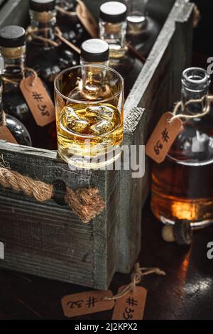 Bourbon mit Eis in einem Glas in der Brennerei. Gealterter Cognac im alten Lagerhaus der Destillerie. Stockfoto