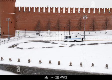 Moskau, Russland - am 28. März 2022 Steht Ein Polizist in der Nähe eines Reiswagens, der auf dem verlassenen Roten Platz geparkt ist. blizzard Stockfoto