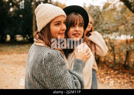 Close beste Freunde Schwestern Wiedersehen nach Streit, streiten, lange Zeit nicht sehen, umarmen, vermissen, vergeben im Herbst Park. Stockfoto