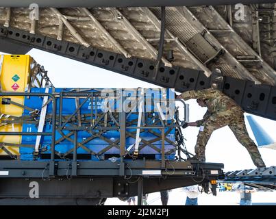 Der Ladenmeister der Texas Air National Guard vom Logistic Readiness Squadron 136. überprüft die Paletten mit Hilfsausrüstung, bevor ein Super Puma-Hubschrauber für den Transport auf einem C-17 geladen wird, der zum Verantwortungsbereich von US AFRICOM am 20. März 2022 im NAS Fort Worth JRB, Texas, geleitet wird. Das Team der Total Force konfigurierte Paletten sowie die Rotorblätter und den Hubschrauber, um auf eine C-17 aus Dover, D., zu passen, führte die gemeinsame Inspektion durch und lud die einzigartigen Flugzeuge fachmännisch für Such- und Rettungsmissionen ein. (Foto der US Air National Guard von SRA Charissa Menken) Stockfoto