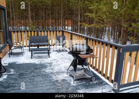 Barbecue-Grill auf der Terrasse eines Landhauses im Wald. Stockfoto