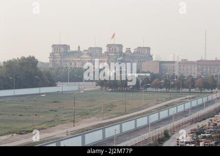 Blick auf West-Berlin gegenüber der Mauer von Ost-Berlin, zeigt das Brandenburger Tor und den Reichstag im Hintergrund 22.. September 1989. Stockfoto