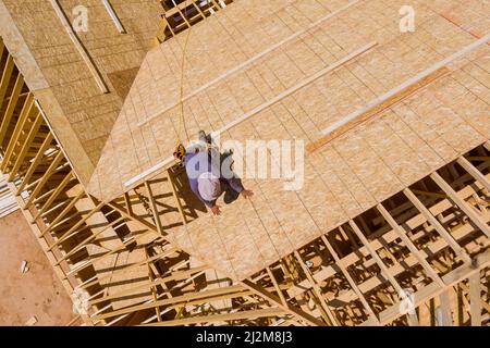 Dachdecker arbeiten auf Hausdach Baustelle mit allen installierten neuen Sperrholz Stockfoto