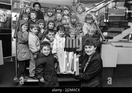 Luke Walker, von der Martsden Nursery School, wird mit Klassenkameraden gesehen, die W H Smith¿ Geschäft in Huddersfield besucht haben, wobei die stellvertretende Geschäftsführerin Frau Alison Ledger ein anderes farbliches Papier zeigte. Der Besuch war Teil¿neuesten Themenprojekts der Schüler auf Papier. Sie haben sich Zeitungen, verschiedene Papiersorten und die Verwendung von Papier angesehen. Sie haben Modelle hergestellt und in ihrer kreativen Arbeit anderes Papier verwendet. Bei Smith¿ wurde ihnen die Palette der im Handel angebotenen Papierprodukte gezeigt. 4.. Februar 1991. Stockfoto