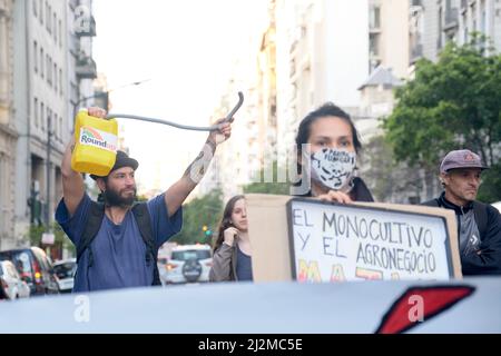 Buenos Aires, Argentinien; 11 2021. November: Menschen marschieren gegen den Einsatz von Pestiziden; Mann hält einen Container Roundup, Frau mit einem Zeichen gegen Mon Stockfoto