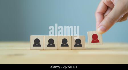 Personalmanagement, Rekrutierung und Zielkundengeschäft. Die Hand des Mannes setzt eine rote Person aus Holzwürfel, die auf der Menge mit Schwarz steht Stockfoto