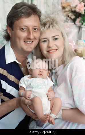 Der britische Darts-Spieler Eric Bristow posiert zu Hause mit seiner Frau Jane und ihrem neugeborenen Mädchen namens Louise. 29.. August 1991. Stockfoto